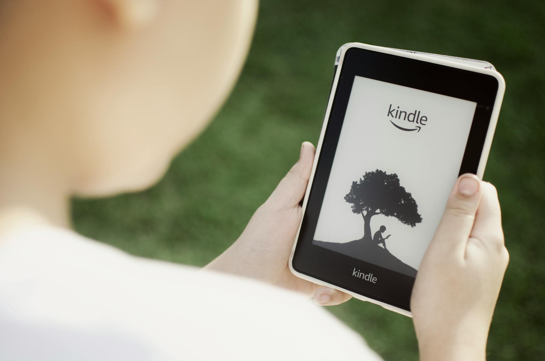 close up of a boy holding a kindle ebook reader