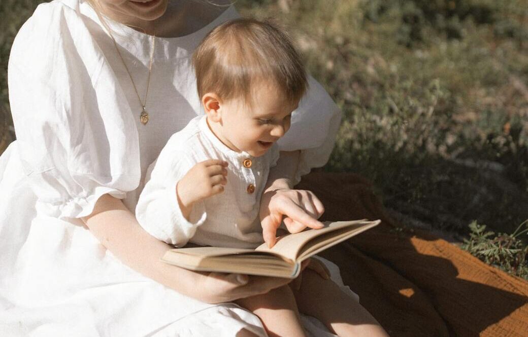 photo of mother and baby reading a book