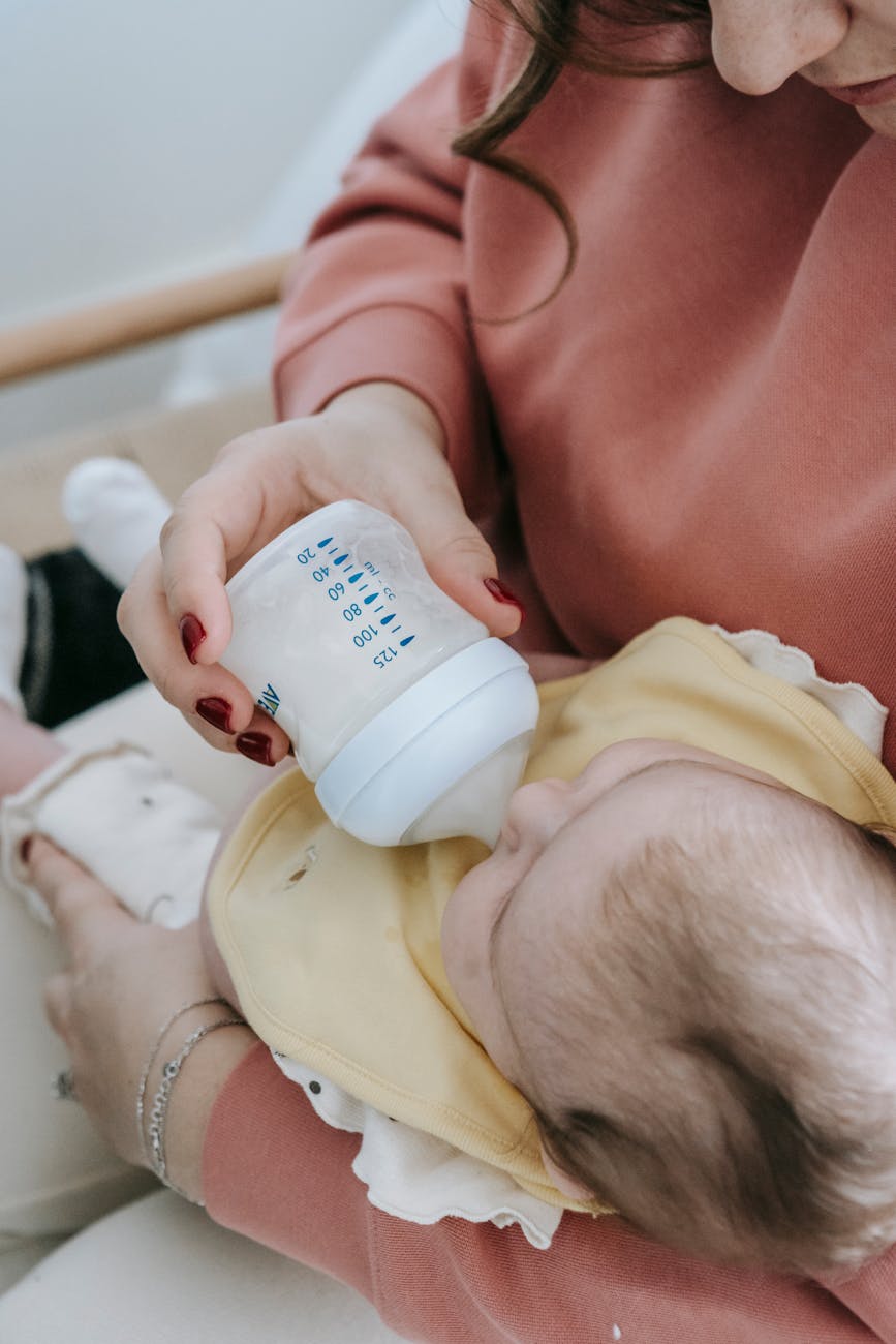 mother feeding child with milk